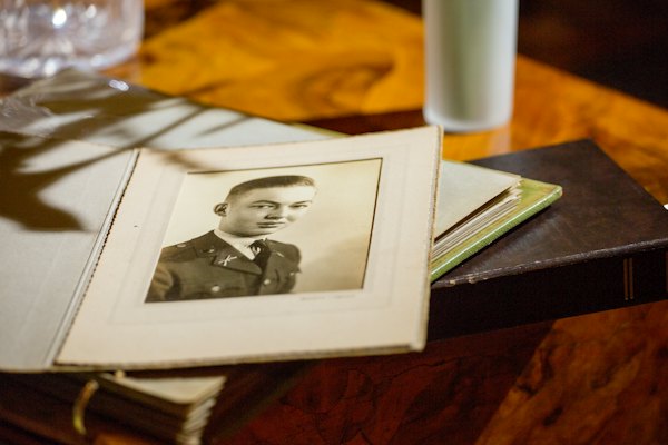 An old studio portrait in a paper folder lying on a wooden table in warm light.