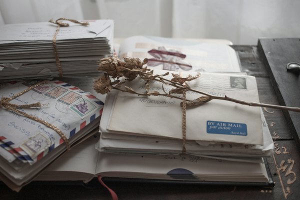 Bundles of old letters and airmail envelopes tied with string and dried flowers.